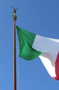Close-up of the Italian Flag on a Flagpole against a Clear Blue Sky